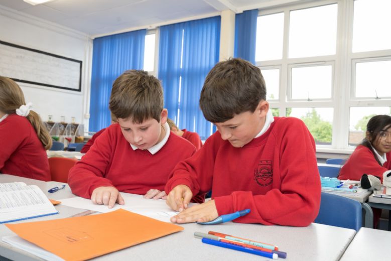 Two children working with exercise books.
